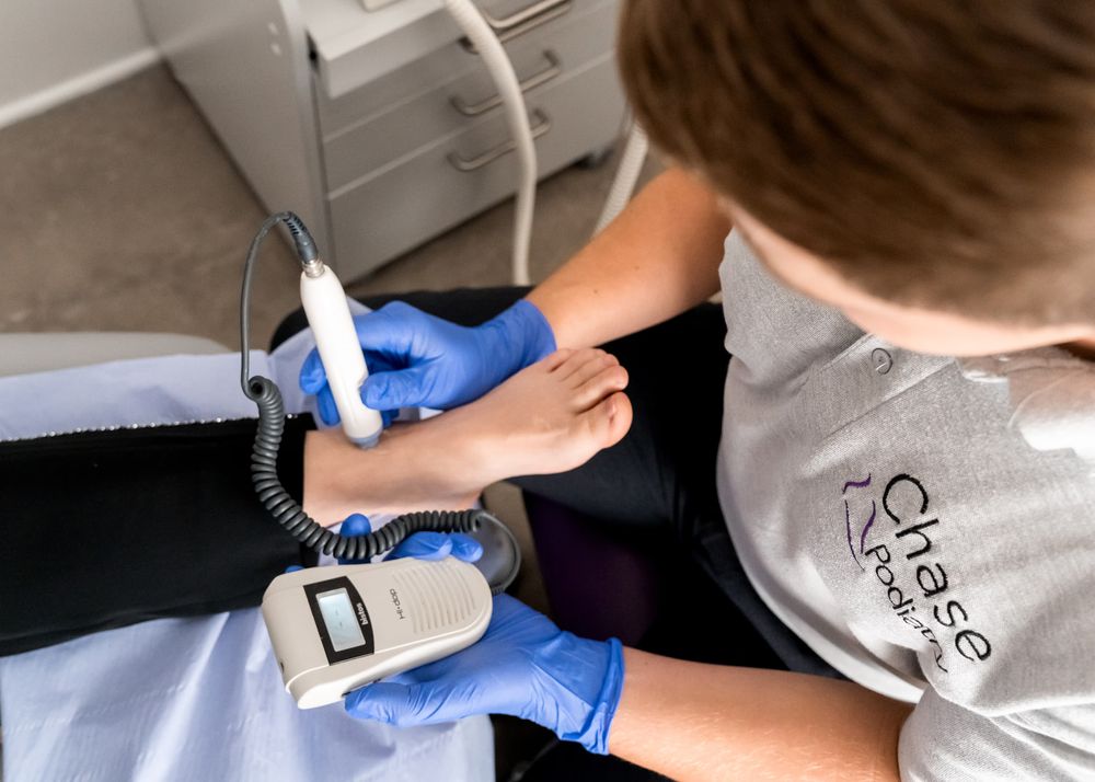 A Chase Podiatry podiatrist performing a doplar examination on a patients foot